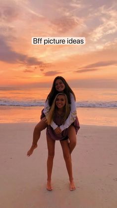 two women are on the beach and one is holding another woman in her arms with an orange sunset behind them