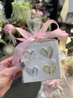 someone holding up a small gift box with hearts on it