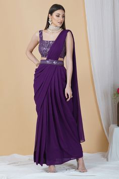 Get ready to leave everyone awestruck with your grace by adorning this ready to wear saree in a dreamy purple hue. With a belt running across and a tie-knot at back, this saree can be perfectly worn for an engagement or a cocktail party.Style Ready to Wear Saree with an embellished belt Dreamy Purple hue Sequins blouse Georgette fabric Specifications Model height - 5'9" Model wearing - S Purple Embellished Pre-draped Saree, Embellished Purple Pre-draped Saree, Elegant Purple Pre-draped Saree, Purple Embellished Georgette Pre-draped Saree, Pre-draped Purple Saree With Mirror Work, Purple Floor-length Pre-draped Saree For Reception, Purple Zari Work Pre-draped Saree For Reception, Purple Georgette Pre-draped Saree For Evening, Traditional Purple Pre-draped Saree For Party