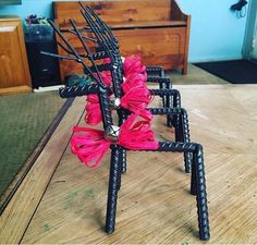 a chair made out of sticks with pink flowers on it sitting on top of a wooden table