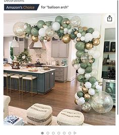 a living room filled with furniture and balloons in the shape of an arch on top of a kitchen island