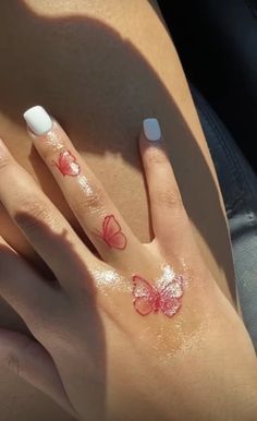 a woman's hand with butterfly tattoos on it