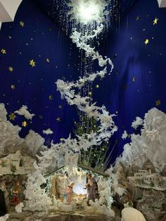 a nativity scene is shown in the middle of a room with blue walls and white clouds