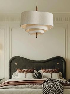 a bedroom with a large bed and two lamps hanging from it's ceiling fixture