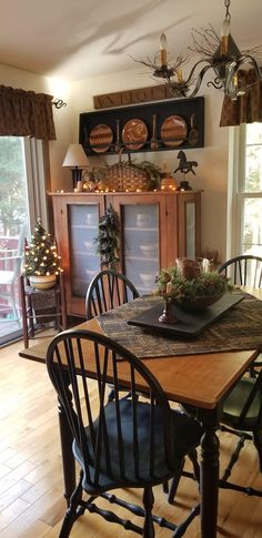 the dining room table is set for two with black chairs and an antlers head above it