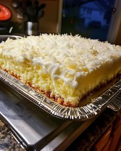 a piece of cake sitting on top of a metal pan covered in white frosting