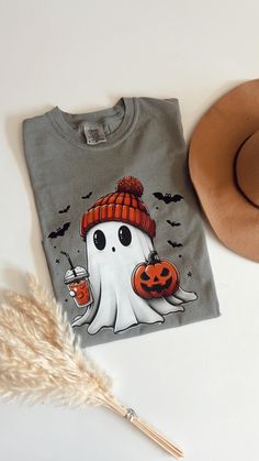 Comfort Colors® Halloween Ghost Shirt, Cute Halloween Shirt, Halloween Women's Shirt, Spooky Season Shirt, Trick or Treat Shirt, Pumpkin Comfort Colors Grey Tshirt  Shirts run true to unisex sizing. Comfortable for both men and women.Please order your regular size for a regular fit, or size down for a more fitted look. Please note unisex shirts are longer than women's shirts. Details: - 100% Cotton - Machine Wash - Soft washed garment dyed fabric - Double needle collar - Twill taped neck and sho Spooky Cartoon Print T-shirt For Fall, Fall Spooky Cartoon Print T-shirt, Halloween Novelty Streetwear Top, Pre-shrunk Long Sleeve Halloween Shirt, Spooky Long Sleeve Shirt For Halloween, Halloween Long Sleeve Shirt With Funny Print, Funny Print Long Sleeve Shirt For Halloween, Spooky Halloween Tops, Halloween Novelty Shirt With Graphic Print