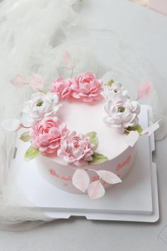 a white cake with pink flowers on top