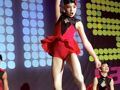 a woman in a short red dress on stage