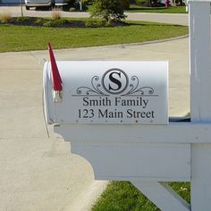 a mailbox with the letter s on it is sitting in front of a house