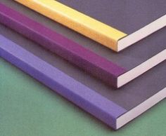 three different colored pencils sitting next to each other on top of a green surface