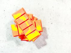 orange and yellow pieces of candy sitting on top of each other in front of a white background