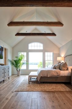 a large bed sitting in a bedroom next to a tv on top of a dresser