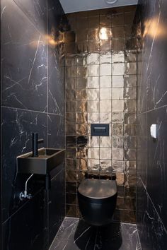 a black toilet sitting in a bathroom next to a sink