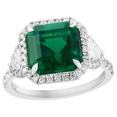 an emerald and diamond ring set in white gold