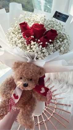 a teddy bear holding a bouquet of flowers