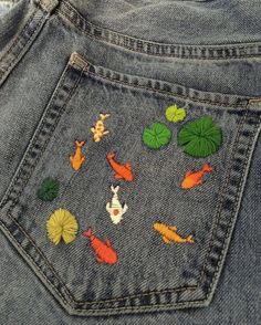 the back pocket of a pair of jeans with fish and lily pads on it