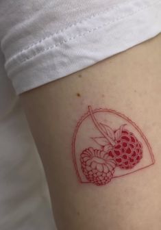 a small tattoo on the side of a woman's leg with raspberries and cherries