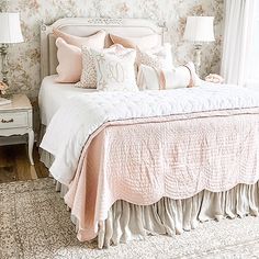 a bedroom with floral wallpaper and bedding in pink, white and gold colors