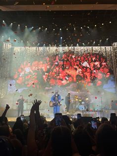 a large group of people standing on top of a stage with confetti in the air