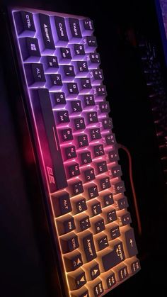 a glowing keyboard is lit up with red and purple lights on it's side