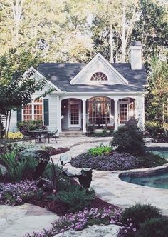 a house with a pool in front of it and landscaping around the back yard area