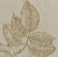 an embroidered piece of cloth with two leaves on the top and one leaf in the middle