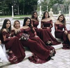 the bridesmaids are all dressed in burgundy dresses and posing for a photo together