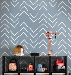 a shelf with some toys on it in front of a wallpapered background that looks like waves