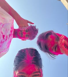 three girls are covered in pink paint and posing for the camera with their hands up