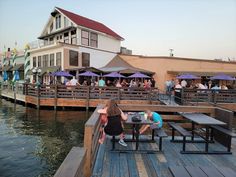 people are sitting at tables on the dock