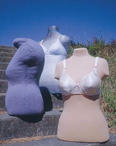 three mannequins are sitting on the steps with one wearing a bra top