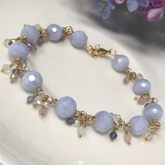 "The Hydrangea Bracelet. This luxurious piece features AAA Blue Lace Agate with beautiful swirls of powdery sky blue. Clusters of AAA periwinkle Tanzanite, creamy freshwater Pearls, white topaz and petal pink rose quartz cascade between each blue lace agate. All gemstones are faceted for maximum sparkle and shine, and everything is intricately wrapped in your choice of 14kt yellow gold filled, 14kt rose gold filled or sterling silver. A highly polished lobster claw clasp completes the design. Th Blue Lace Agate Jewelry, Light Blue Bracelet, Blue Lace Agate Bracelet, Tanzanite Bracelet, Cluster Bracelet, Sea Glass Bracelet, Silver Opal Ring, Blue Beaded Bracelets, Cluster Bracelets