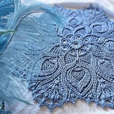 a blue doily with feathers on top of it