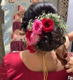 a woman is getting her hair done with flowers