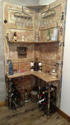 a wine cellar with several bottles and glasses on the shelves in it's corner