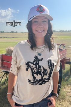 Unleash your wild side with our High Horse Tee! This Western-chic top exudes confidence and daring, perfect for those who crave adventure. Let out a yeehaw and ride into the sunset with style. Black embroidered design Studs on sleeves. Cream-colored tee. 100% Polyester. The sizing chart is located in the pictures. Western Style Distressed Cotton Tops, Western Style Graphic Print Tops For Summer, Western Tops With Graphic Print For Summer, Black Western Style Tops For Summer, Outdoor Short Sleeve Tops For Fall, Outdoor Fall Short Sleeve Tops, Short Sleeve Tops For Outdoor Fall Events, Short Sleeve Tops For Fall Outdoor, Short Sleeve Tops For Fall Outdoor Events