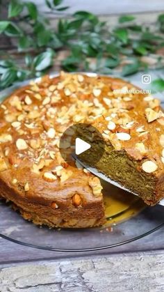 a cake on a glass plate with a knife in it and some leaves around it