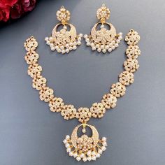 Featuring a harmonious floral pearl necklace with chandbali earrings in 22ct gold. The necklace set has been adorned with freshwater pearls. The weight of the necklace is 25.77 GMs including 1.58 GMs in hanging pearls. The earrings weigh 16.04 GMs including 3.14 in hanging pearls. Price Breakup Summary Component Rupees % of Total 22k Gold 188,778 76.4% Stones & Beads 17,134 6.9% Making Charges 33,980 13.8% Taxes (GST) 7,197 2.9% Total 247,089 100.0% View Detailed Price Breakup Elegant Kundan Necklace For Eid, Elegant Round Kundan Necklace For Eid, 22k Gold Pearl Necklace For Diwali, Celebration Kundan Chandbali Necklace With Elegant Design, Diwali Chandbali Pearl Necklace For Reception, Chandbali Pearl Necklace For Diwali Reception, Gold Chandbalis For Eid Reception, Gold Chandbali Pearl Necklace In Temple Style, Gold Chandbali Pearl Necklace In Temple Jewelry Style