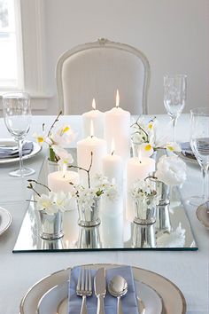 a table set with silverware and white flowers