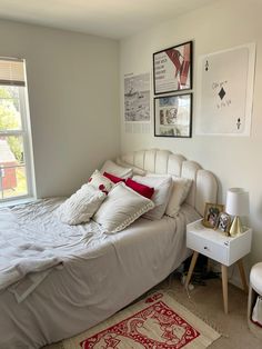 a white bed sitting next to a window in a bedroom on top of a rug