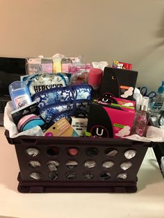 a black basket filled with lots of items on top of a white counter next to a laptop