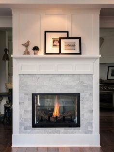 a white fireplace with a fire place and pictures on the mantle