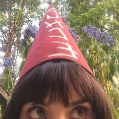 a close up of a person wearing a red party hat with the word happy written on it