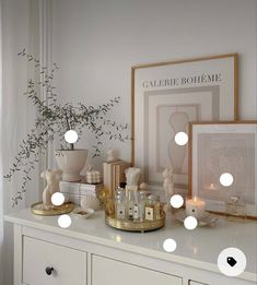 a white dresser topped with lots of different types of decorations and lights on top of it