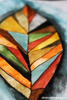 a colorful piece of stained glass sitting on top of a table