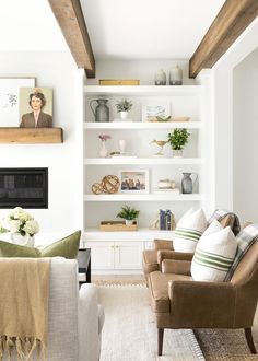 a living room filled with furniture and bookshelves next to a fire place on a wall