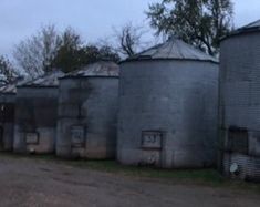 several metal silos lined up on the side of a road