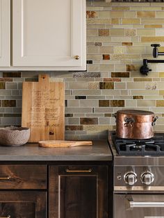 a wooden cutting board sitting on top of a counter next to a stovetop oven