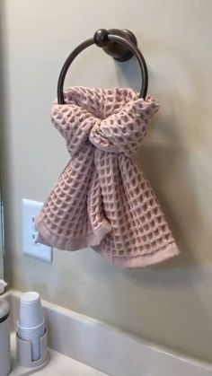 a pink towel hanging on a hook in a bathroom